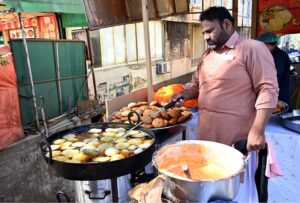 A vendor busy frying traditional food item (Kachori) for iftar near G-7 area in the Federal Capital