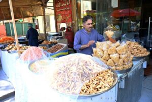 A vendor busy frying traditional food item (Kachori) for iftar near G-7 area in the Federal Capital