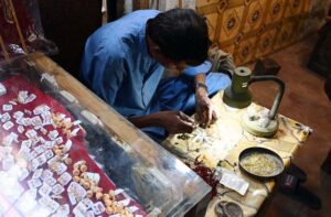 A worker is busy preparing gold jewelry at his workplace in Shahi Bazaar.