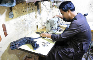 Artisan is busy sewing leather before preparing sandals for sale at a local sandal factory in Fort Area, in connection with the upcoming Eid-ul-Fitr.