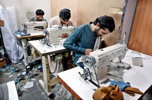 Tailors busy in stitching clothes of customers for preparation of upcoming Eid ul-Fitr.