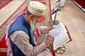 A faithful reciting Holy Quran in a mosque during Holy Fasting Month of Ramzan.