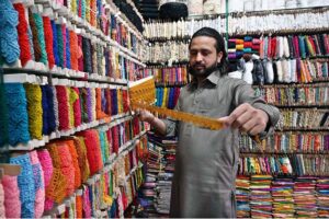 A person purchasing shoes from a shop in Aabpara Market as people shopping for preparation of upcoming Eidul Fitr