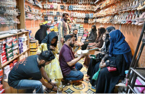 Women busy selecting sandals at a shoe shop in Latifabad Market in preparation for the upcoming Eid al-Fitr.