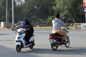 A woman on the way traveling on her scooty at college road