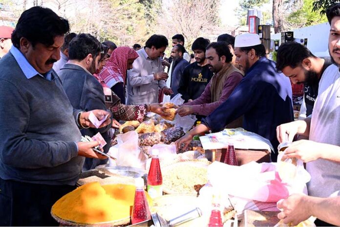 People purchasing different food items from stall for iftar at Sasta Ramadan bazaar Aabpara in the Federal Capital