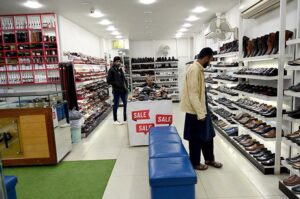 A man selects shoes at a shop in Aabpara, Federal Capital