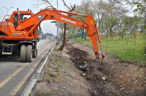 Workers diligently clean the green belt along Srinagar Highway in the Federal Capital for new plantation ahead of the coming spring season.