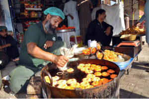 A worker preparing traditional sweet item Amriti use for iftar at Hyder chowk