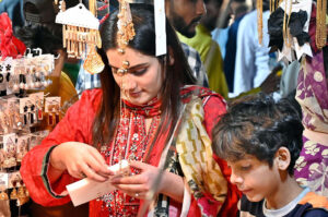 A lady selects to purchase artificial jewelry from a vendor in preparation of the upcoming Eidul Fitr at Latifabad market.