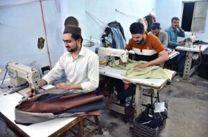 Tailors are busy stitching clothes at their workplace in Tilak Chari area.