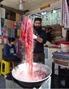 A worker busy in dying ladies scarf “Dupatta” at Aabpara Market in Federal Capital