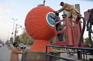 Cantonment workers installing a clock in an orange model at Rehman Plaza Chowk for beautification of the city.