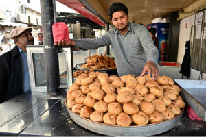 Workers busy in preparing traditional food item samosas before frying at their workplace during the Holy Month of Ramadan-ul-Mubarak