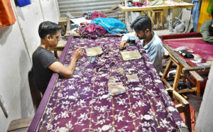 Skilled craft man preparing embroidery fancy clothes due to the increased demand for upcoming Eid-ul-fitr at resham bazaar.