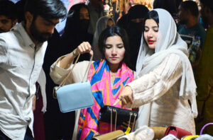 Lady police constable standing high alert during Women busy shopping in preparation for the upcoming Eid-ul-Fitr at Resham Gali Bazaar.