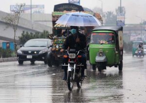 A motorcyclist on the way carrying an umbrella to protect from rain that experienced in the Provincial Capital