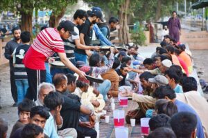 Volunteers distribute sweet drinks to the faithful for Iftar at a local park in Latifabad during the holy month of Ramadan