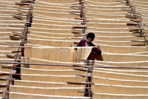 A laborer is hanging and arranging vermicelli (seviyan) to dry after preparing it, as demand has increased during Eidul Fitr.