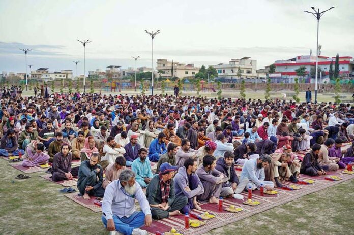 A large number of people waiting for Maghrib Azaan to break their fast arranged by volunteers at greenbelt along Islamabad Expressway