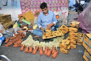 A worker is busy packing sandals into boxes at his workplace after preparing them, ready for transportation to other markets ahead of Eid-ul-Fitr.