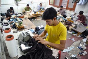 The tailor is occupied with sewing clothes for customers at his workplace in anticipation of the upcoming Eidul Fitr