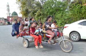 A gypsy family is heading towards their destination on a motorcycle rickshaw on Shadman Main Road.