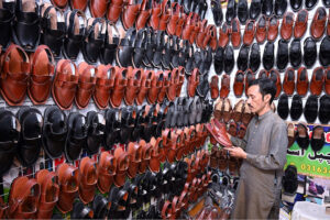 A man busy in selecting and purchasing shoes in connection with upcoming Eid-ul-Fitr at Resham Gali