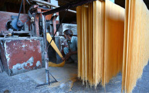 A worker busy in hanging vermicelli to dry after preparing it, as demand has increased during Eidul Fitr.