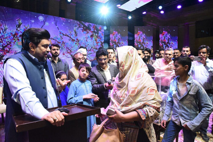 Sindh Governor, Kamran Khan Tessori greets the 120 yards plot lucky draw beneficiary Nadia Iqbal