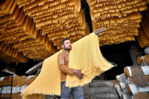 A worker busy in hanging vermicelli to dry after preparing it, as demand has increased during Eidul Fitr.