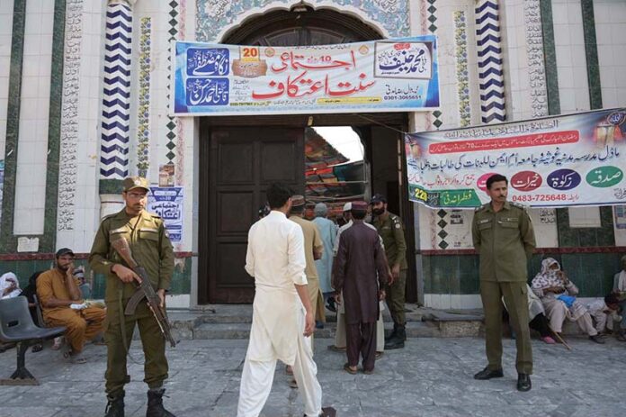 Secutity official standing alert during the third Friday prayer of Ramzan ul Mubarak outside Hamid Shah Masjid