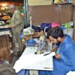 Tailors busy in stitching clothes at their workplace in Islampura