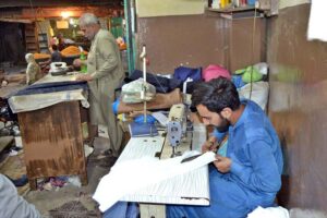 Tailors busy in stitching clothes at their workplace in Islampura