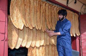 vendor displaying ‘Afghani bread’ to attract the customers at his shop in a local market.