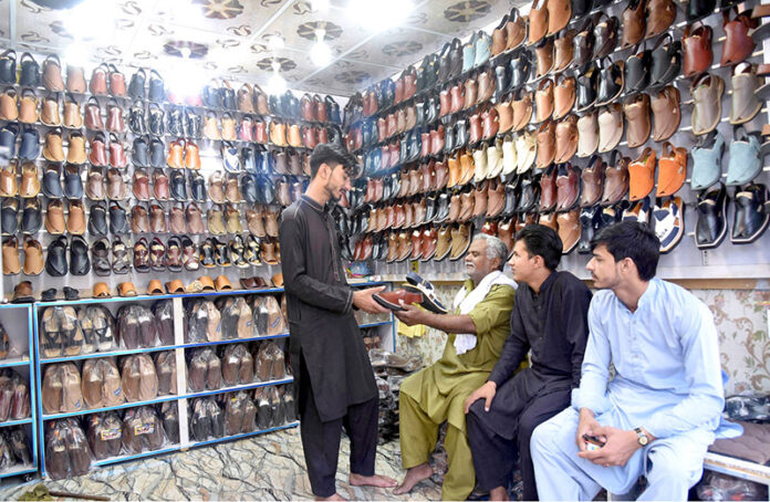 Customers at Chamra Market near Allama Iqbal Road purchasing leather Peshawari Chapal in preparation for the upcoming Eid-ul-Fitr