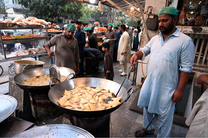 Workers busy in preparing traditional food item Samosa for frying at his workplace at I-10 markaz during Holy month of Ramzan ul Mubarak