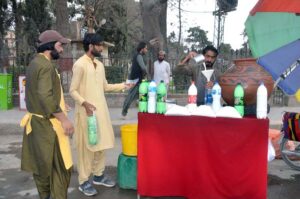 A vendor preparing traditional drink ‘Lassi’ to attract the customers ...