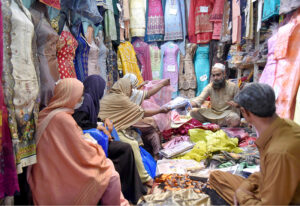 Customers at Chamra Market near Allama Iqbal Road purchasing leather Peshawari Chapal in preparation for the upcoming Eid-ul-Fitr