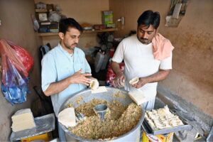 A vendor busy in frying traditional food stuff ‘samosa’ outside his shop during Holy Fasting Month of Ramzan