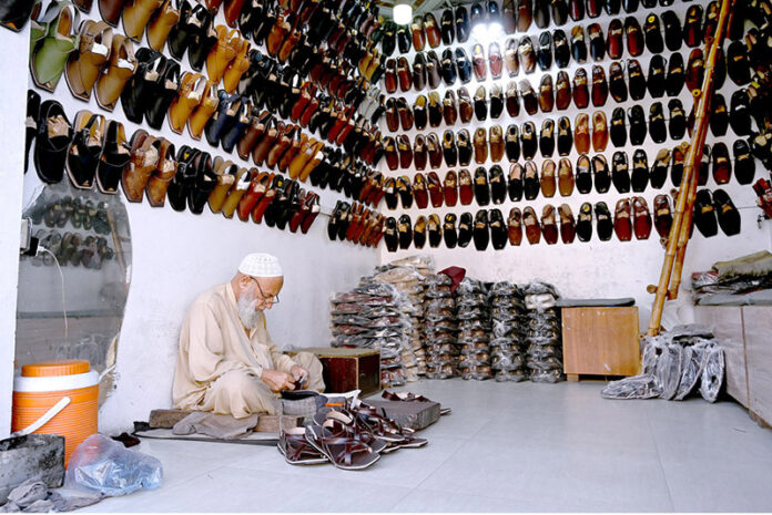 A cobbler preparing traditional shoes at his workplace in the Provincial Capital