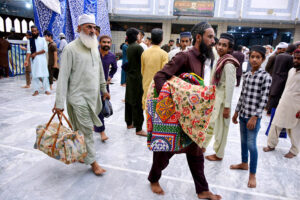 Worshipers entering in Faizan-E-Madina Mosque carrying their belongings to sit for Itikaf, an Islamic meritorious voluntary practice of secluding oneself in a mosque for a period of time, dedicating it to worship and spiritual reflection, typically during Ramadan