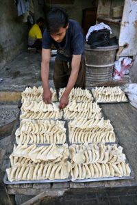 A vendor busy in frying traditional food stuff ‘samosa’ outside his shop during Holy Fasting Month of Ramzan