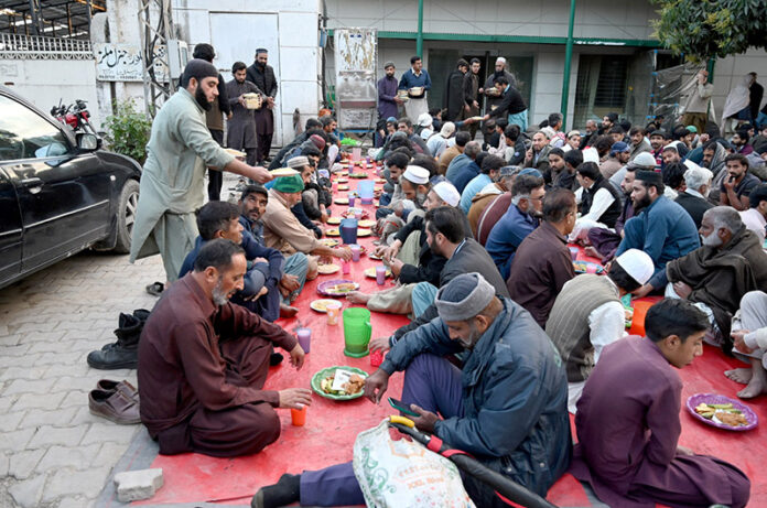 A large number of people break their fast at a free Iftar arrangement along the roadside in the holy month of Ramzan ul Mubarak at I-9 sector in the federal capital