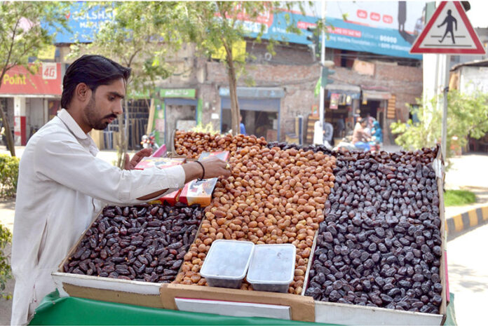 A Date vendor on Chaubarji Road, displaying and decorating different types of dates to attract the customers