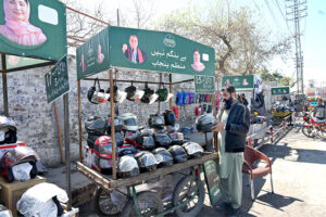 Vendors sells motorcycle helmets on a handcart provided by the government of Punjab