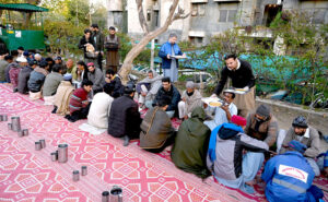 A worker serves free food to people in fasting during Iftar arranged by Umeed Food Trust at G-8 in the federal capital