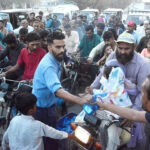 A man distributing Iftari among the commuters near Mazar e Quaid