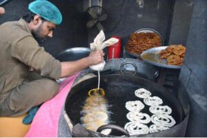 A vendor making a traditional sweet item (Jalebi) at Burns Road for iftar on the first day of holy fasting month of Ramazan