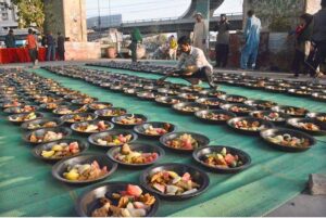 Volunteers distributing food among people to break their fast at roadside setup arrange by philanthropists during holy fasting month of Ramadan.